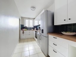 Cuisine lumineuse et équipée avec espace de rangement moderne.