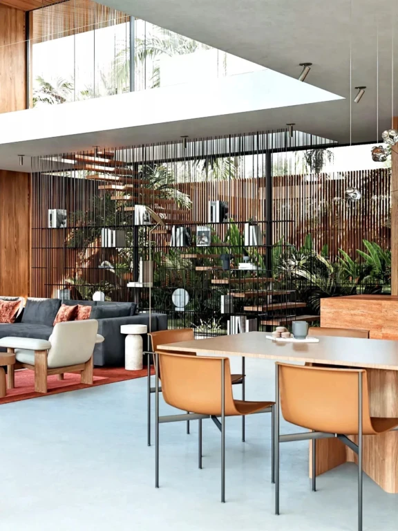 Un salon moderne avec des meubles contemporains, séparé par une étagère métallique. Des plantes vertes ajoutent une touche de nature à l'ensemble.