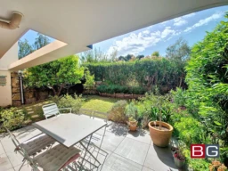 Balcon ensoleillé avec vue sur le jardin verdoyant.