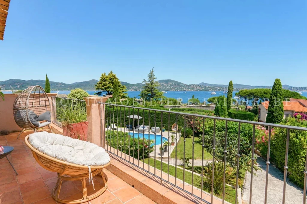 Balcon avec vue panoramique sur la mer et le jardin luxuriant.