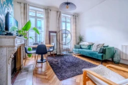Salon lumineux avec cheminée, grandes fenêtres et meubles modernes.