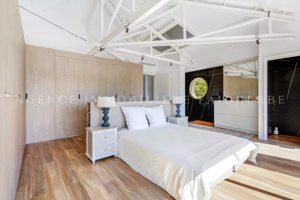 Chambre spacieuse avec un design moderne et lumineux, idéale pour une maison confortable.