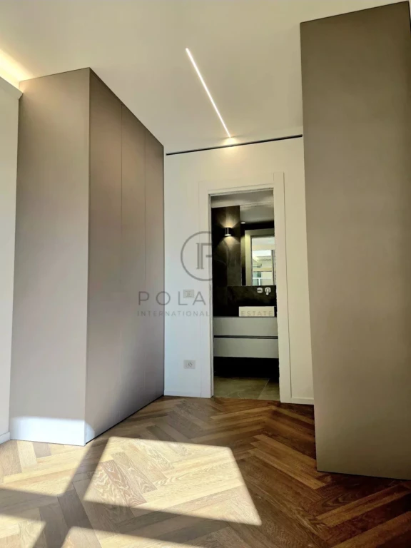 Une pièce moderne avec un parquet en bois et des murs aux tons neutres, illuminée par une lumière naturelle.