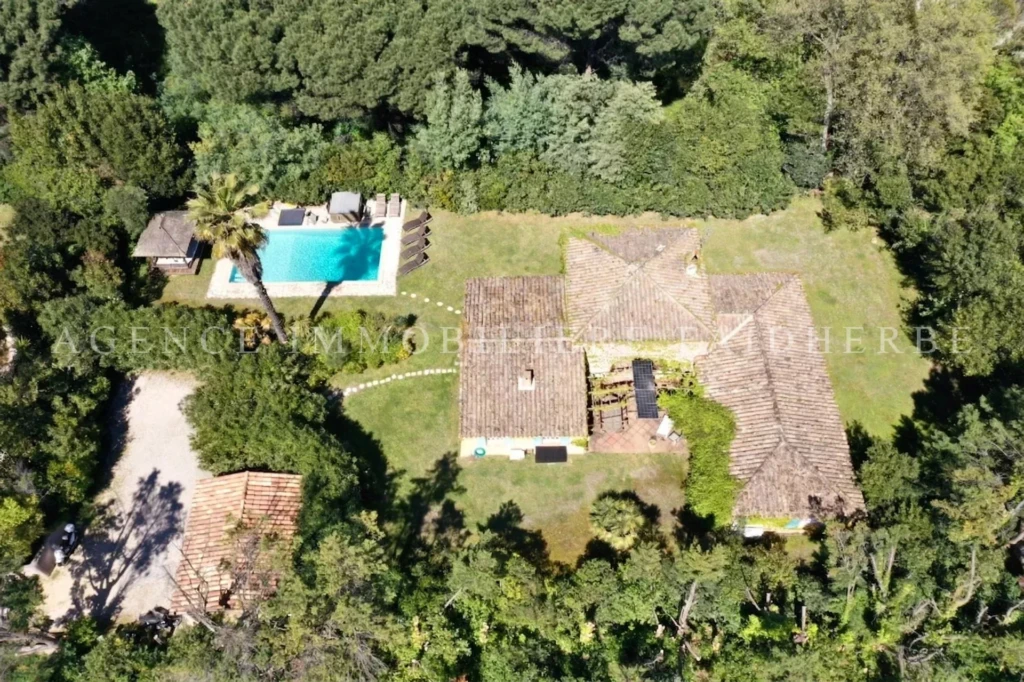 Belle propriété entourée de verdure avec piscine et maison spacieuse.