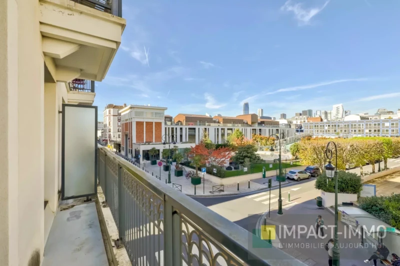 Vue depuis un balcon d'une rue animée avec des bâtiments modernes, ciel dégagé