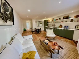Salon lumineux avec canapé blanc et étagères élégantes dans un appartement moderne.