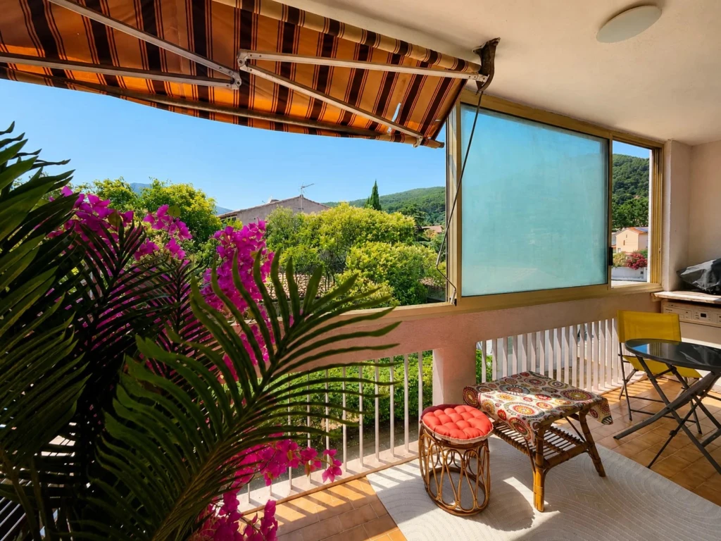 Un véritable espace de détente extérieur avec store banne, fleuri et sans vis-à-vis, offrant une jolie vue verdoyante.