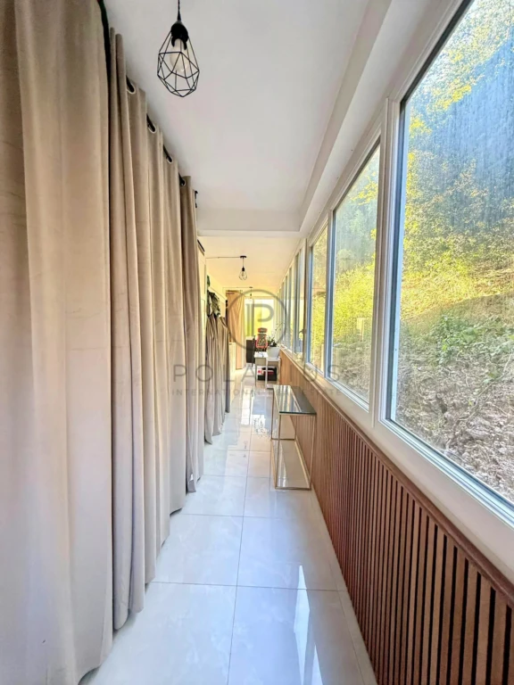 Un balcon lumineux avec vue sur la nature, idéal pour profiter du soleil.