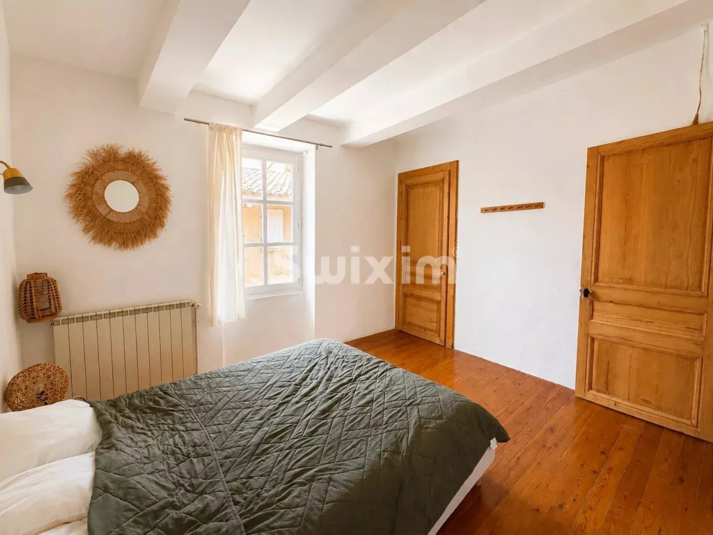 Chambre lumineuse avec parquet en bois, mobilier en bois et décoration chaleureuse.