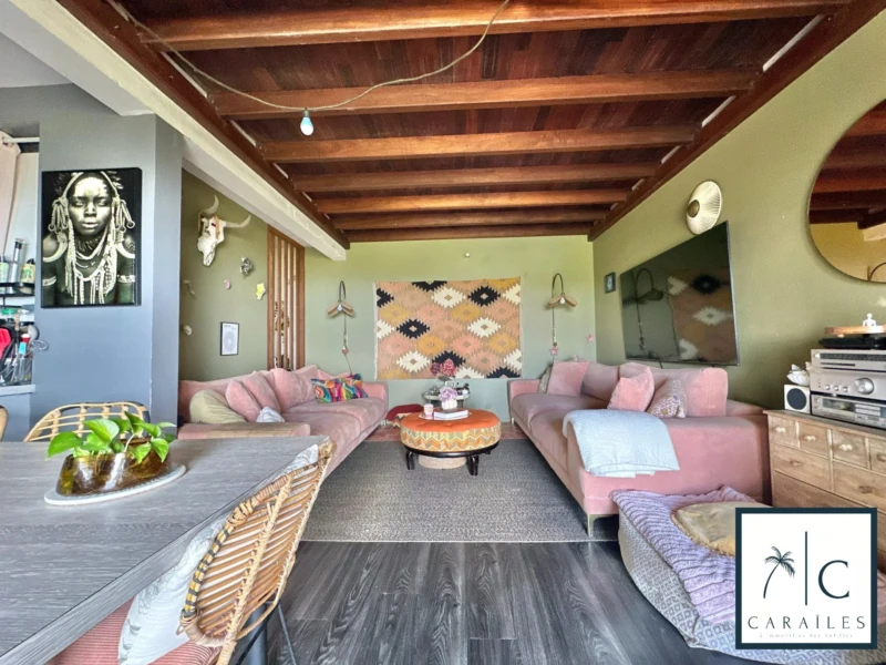 Un salon spacieux et chaleureux avec un plafond en bois et des meubles confortables.
