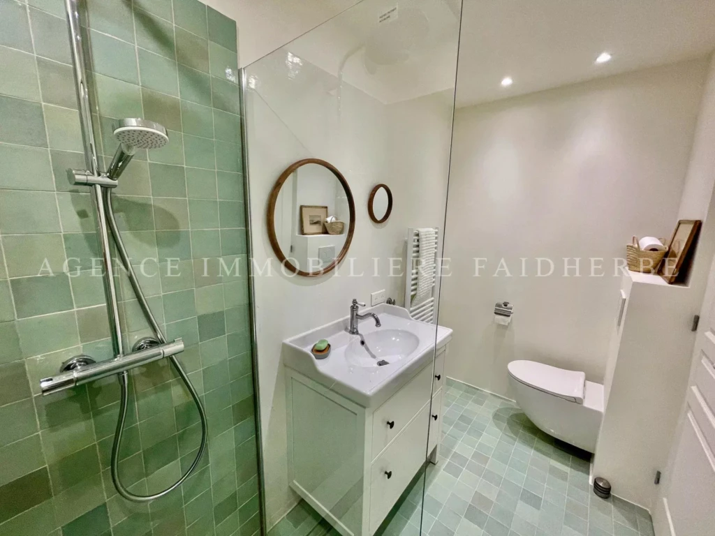 Salle de bain moderne avec une douche à l'italienne et des finitions élégantes.