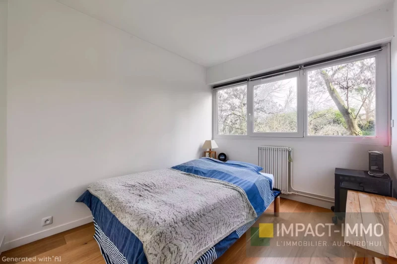 Une chambre lumineuse avec emplacement pour un lit double et une grande fenêtre donnant sur des arbres.