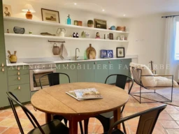 Cuisine moderne et chaleureuse avec des étagères décoratives.