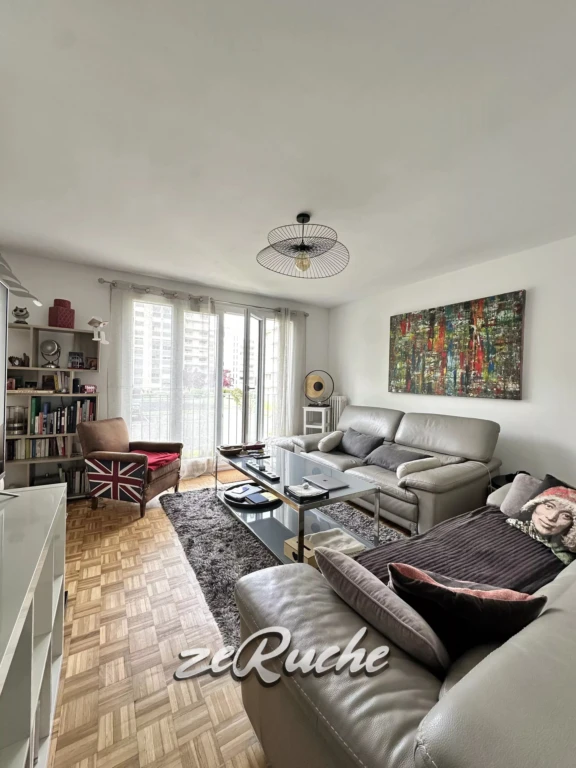 Un salon lumineux avec un mobilier moderne et une grande fenêtre offrant une vue sur l'extérieur.