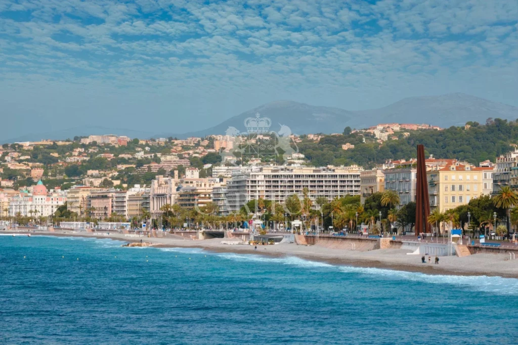 Picturesque scenic view of Mediterranean sea coast in Nice, France. Mediterranean Sea waves surging on the coast, people are relaxing on the beach. Nice, France