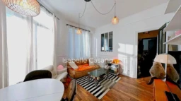 Charmant salon lumineux avec des fenêtres spacieuses et une décoration moderne.
