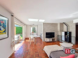 Salon lumineux avec cheminée et vue sur le jardin.