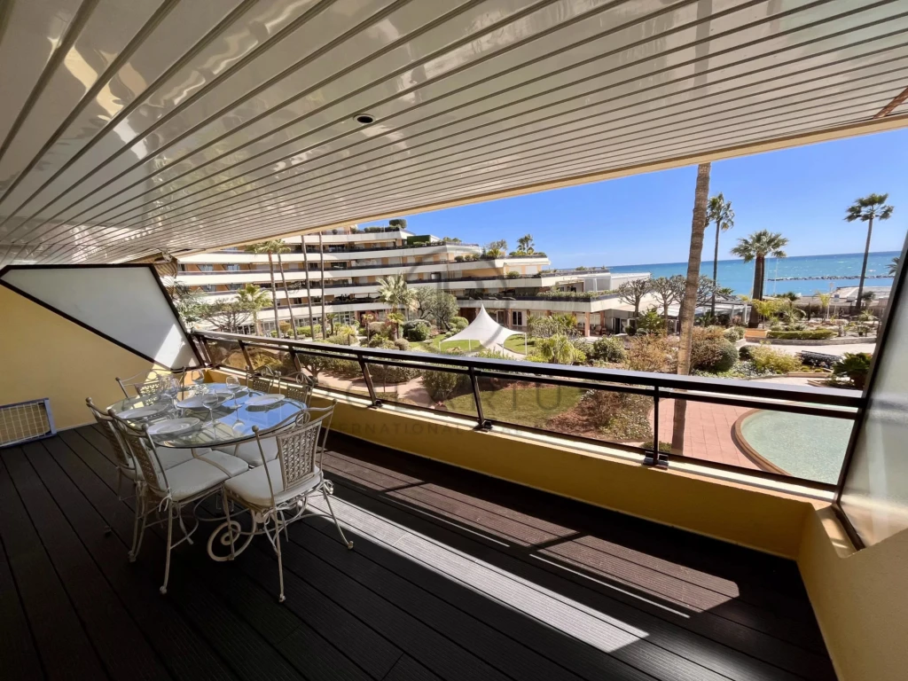 Balcon avec vue sur la mer et espace pour déjeuner en plein air.