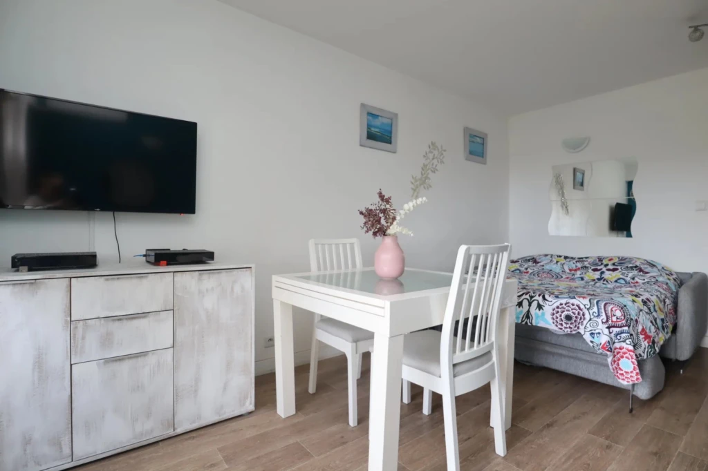 Coin repas convivial et espace TV dans un studio optimisé et meublé à Hyères.