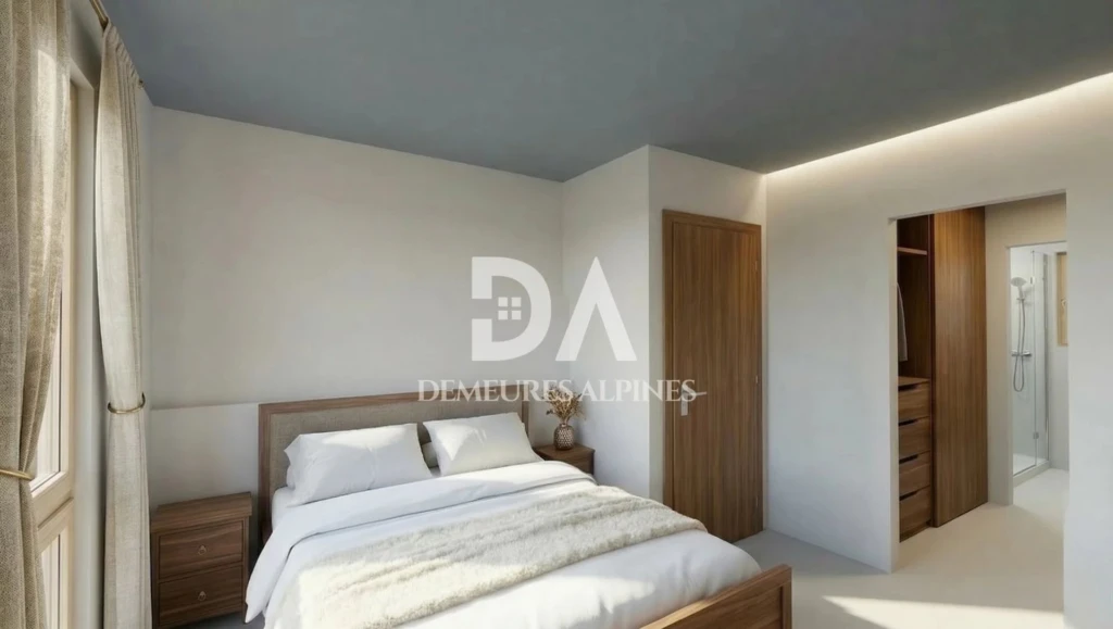 Chambre lumineuse avec mobilier en bois et salle de bain attenante.