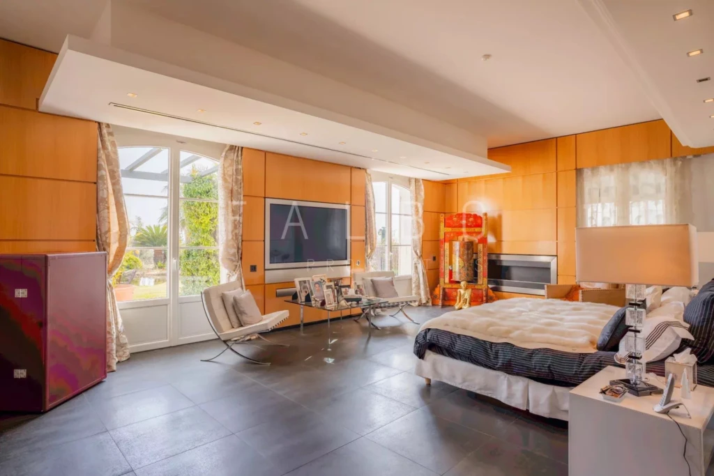 grande chambre avec télé fenêtre et fauteuil