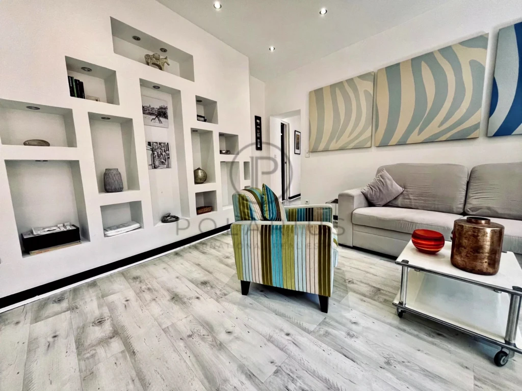 Salon moderne et lumineux avec un mobilier élégant et des rangements intégrés.