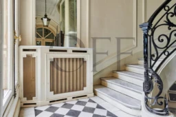 Un élégant hall d'entrée avec un escalier en colimaçon et un sol en damier noir et blanc Paris 7ème Gros caillou.