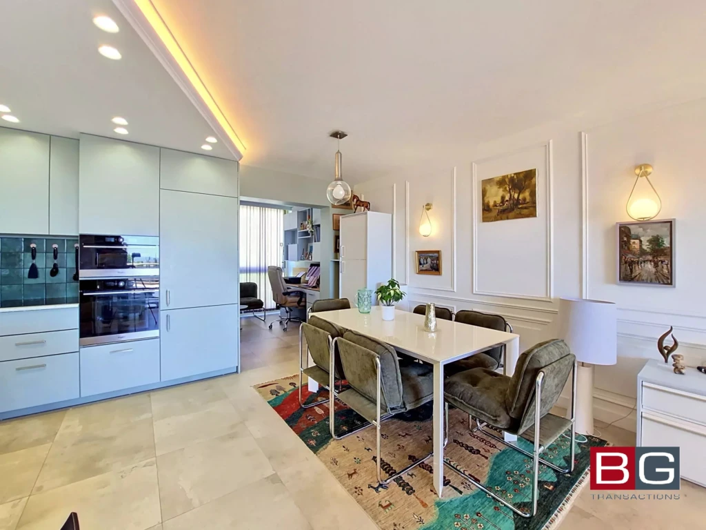 Salle à manger lumineuse dans un appartement moderne avec cuisine ouverte.