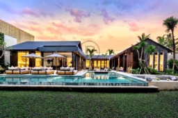 Villa moderne avec piscine, entourée de palmiers et baignée par un coucher de soleil coloré.