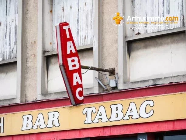 Quillebeuf-sur-Seine, France; August 23rd 2024: A vintage red and white tabac sign hangs on the facade of an aging building. Traditional French bars and tobacco shops.