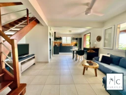 Salon lumineux avec vue dégagée et accès à une terrasse extérieure.