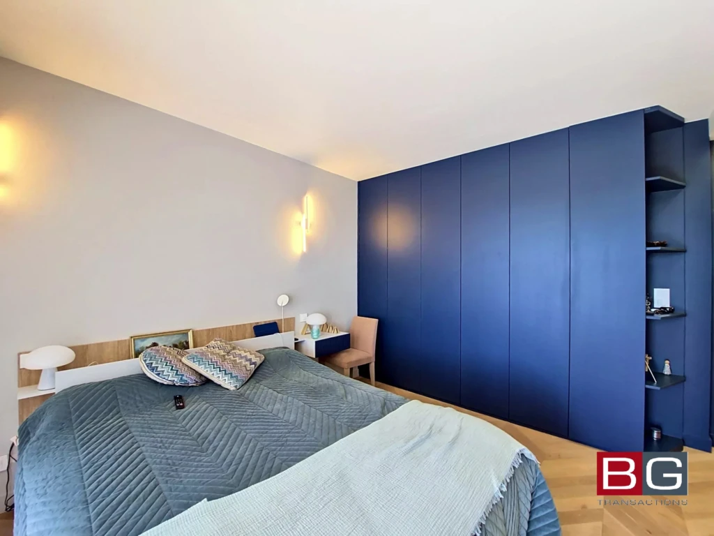 Chambre lumineuse avec un mur bleu contemporain et un mobilier moderne.