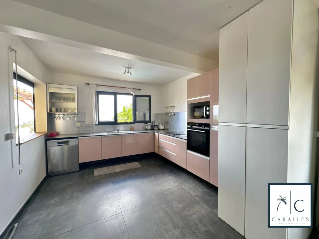 Cuisine lumineuse avec de grands espaces et des appareils modernes.