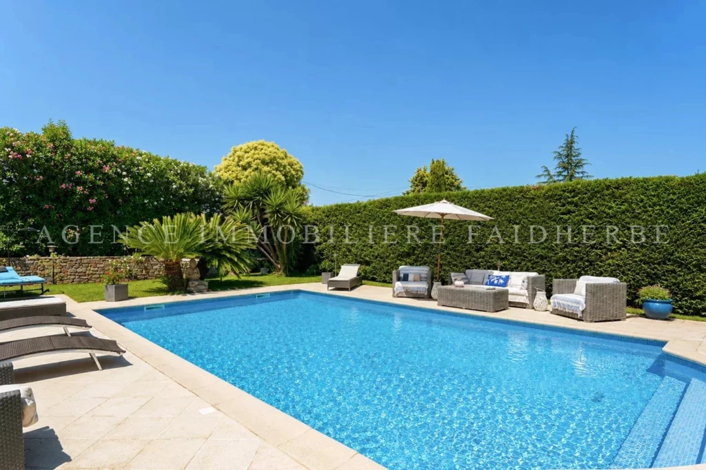 Belle piscine dans un jardin privé impeccablement entretenu.
