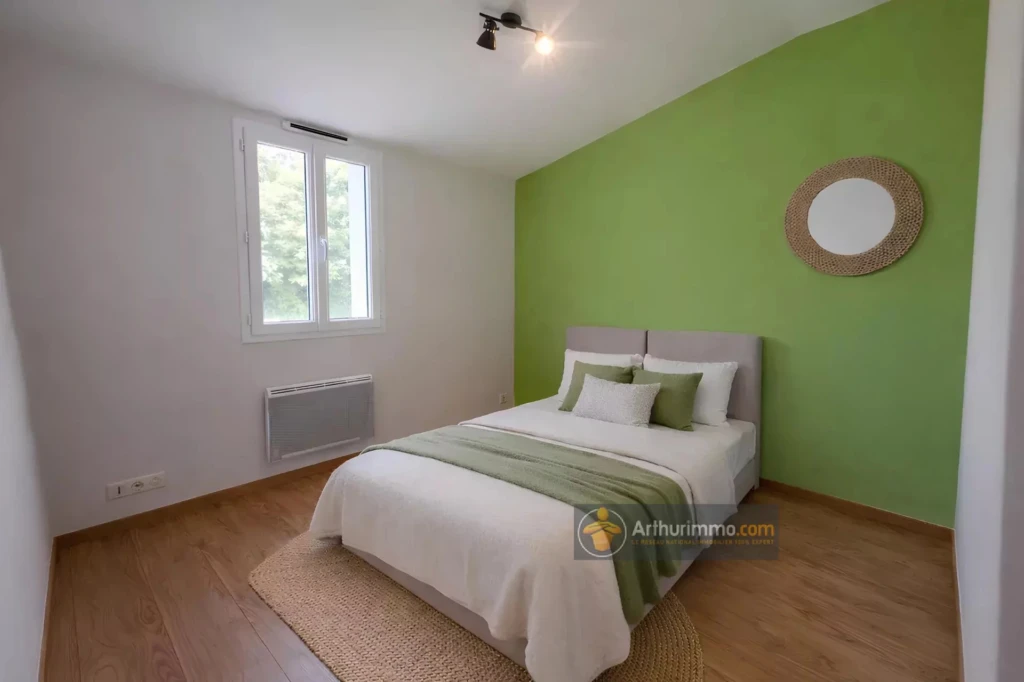Chambre lumineuse avec mur vert vif et lit confortable dans une belle maison.