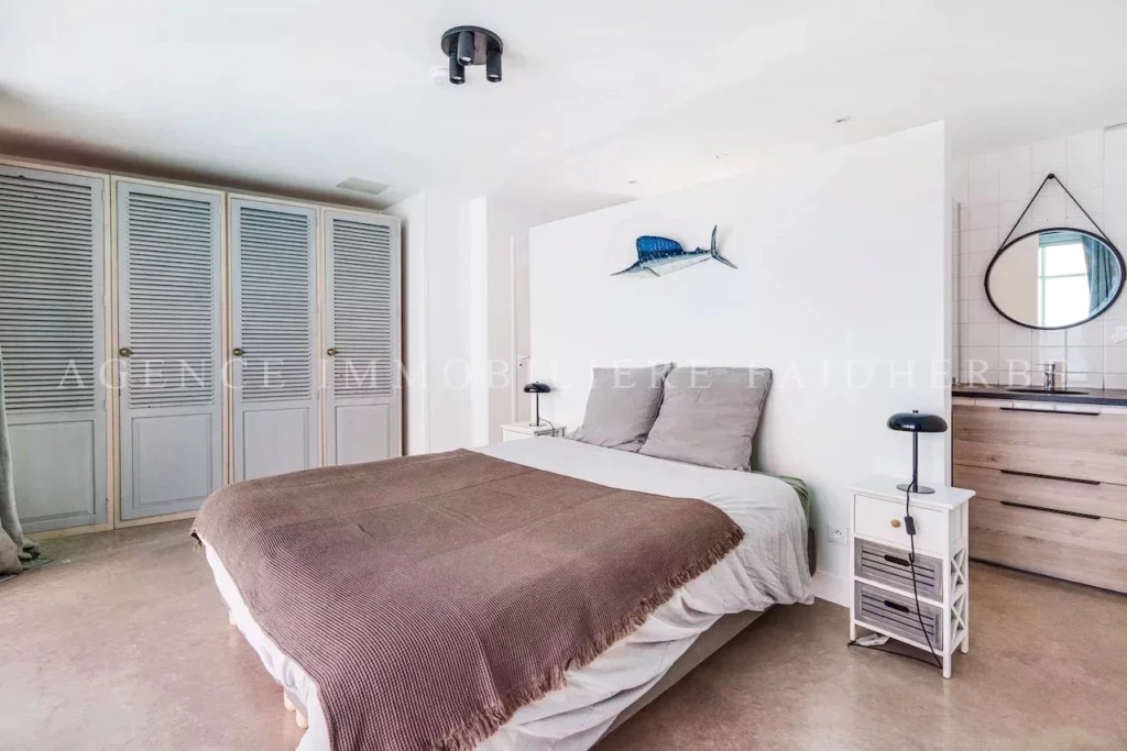 Chambre lumineuse avec un décor moderne et une ambiance calme, idéale pour une résidence confortable.