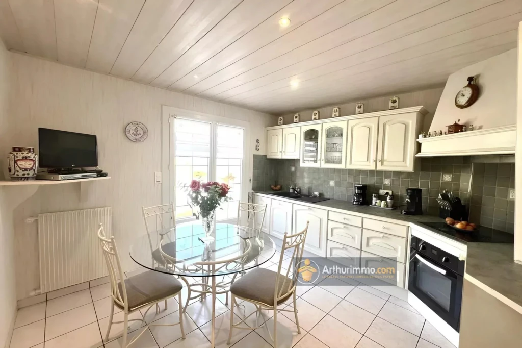 Cuisine lumineuse avec un mobilier blanc élégant et un coin repas convivial.
