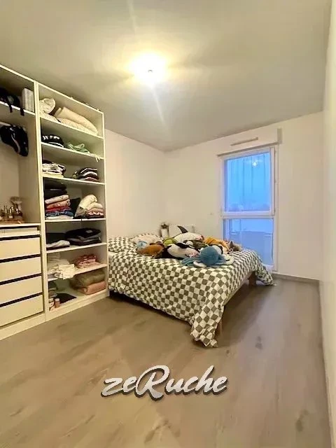 Chambre lumineuse avec grand lit et rangement spacieux, idéale pour une vie confortable.