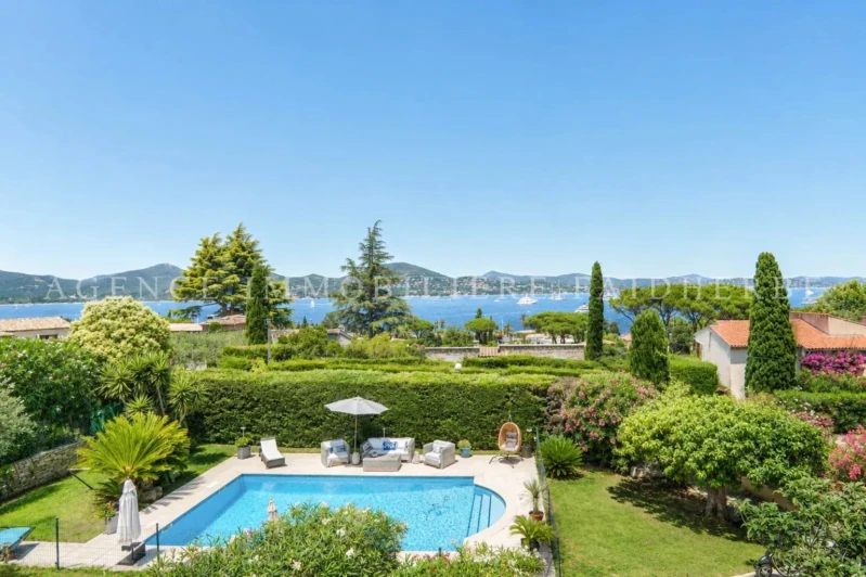 Belle vue sur la mer depuis un jardin avec piscine et jardin paysager.