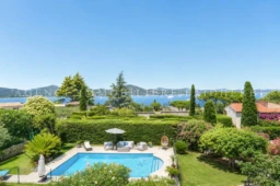 Belle vue sur la mer depuis un jardin avec piscine et jardin paysager.