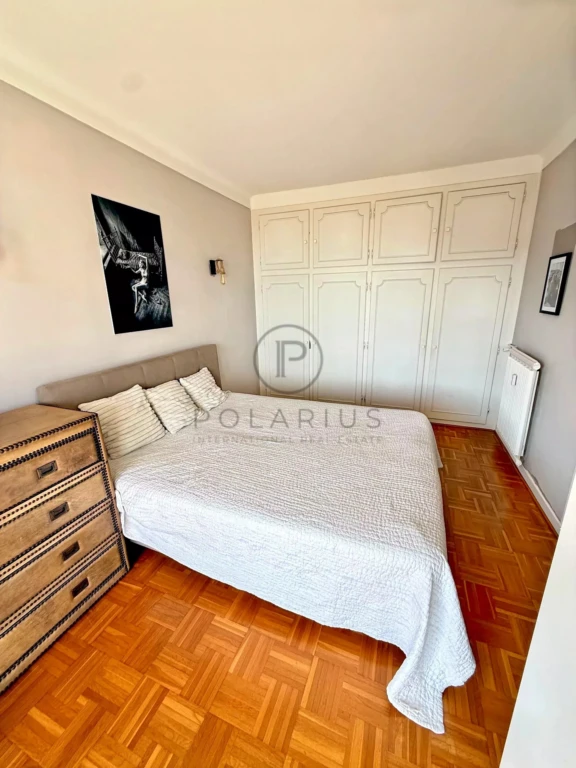 Chambre lumineuse avec grand espace de rangement et parquet en bois.