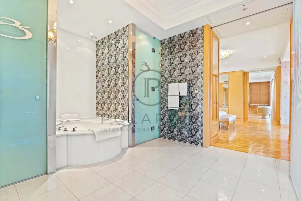Une salle de bain élégante avec une baignoire d'angle, des parois en verre et des motifs en noir et blanc.