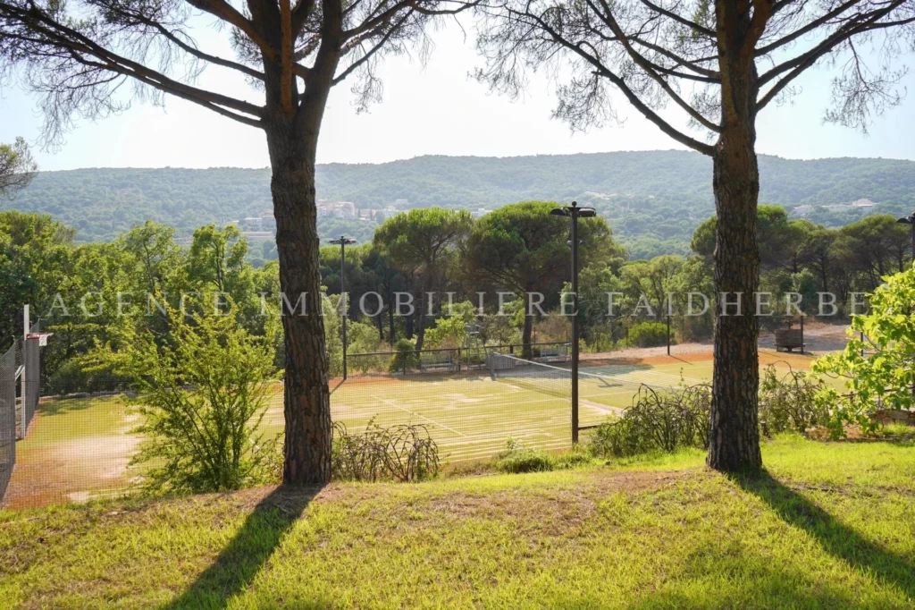 Un magnifique espace extérieur avec des arbres ombragés et un panorama verdoyant.