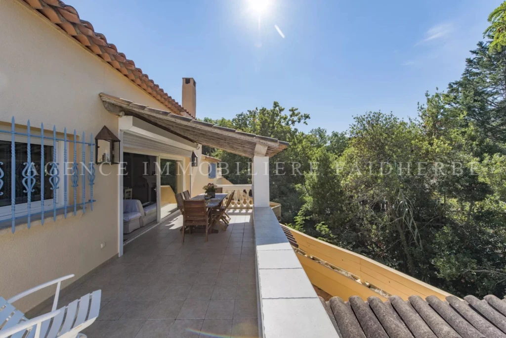 Balcon offrant une vue verdoyante dans une maison lumineux à vendre.