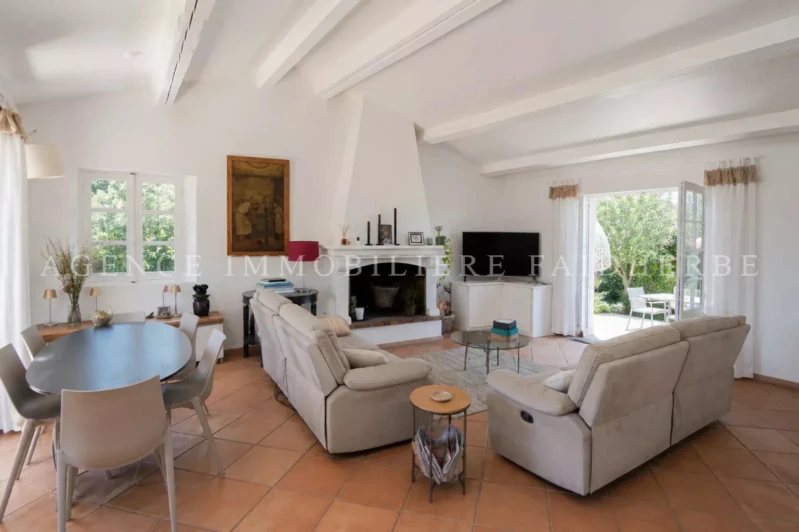Salon spacieux avec cheminée et vue sur le jardin.