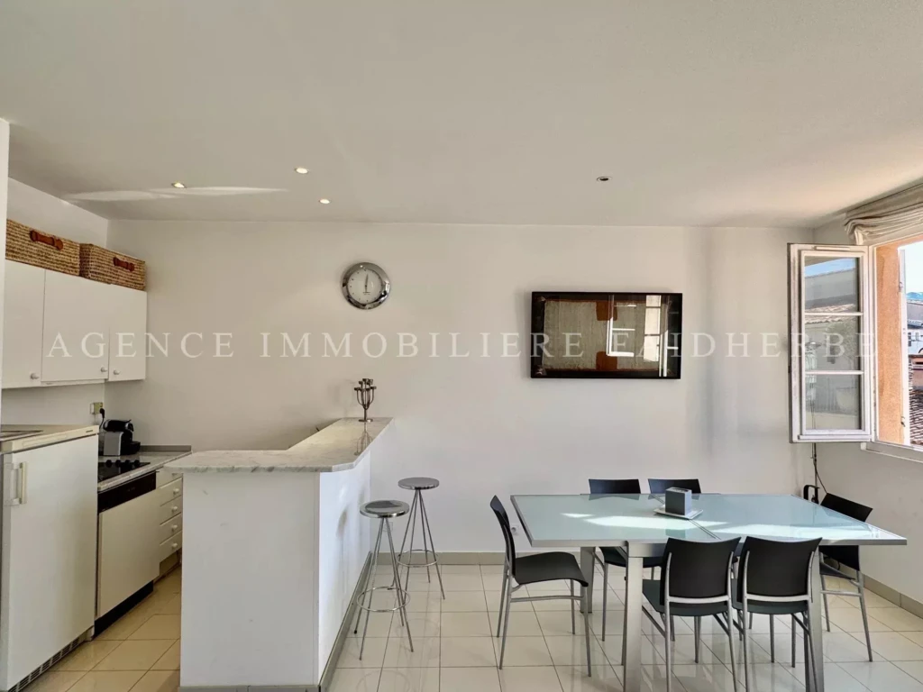 Belle cuisine lumineuse avec espace repas dans un appartement confortable.