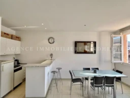 Belle cuisine lumineuse avec espace repas dans un appartement confortable.