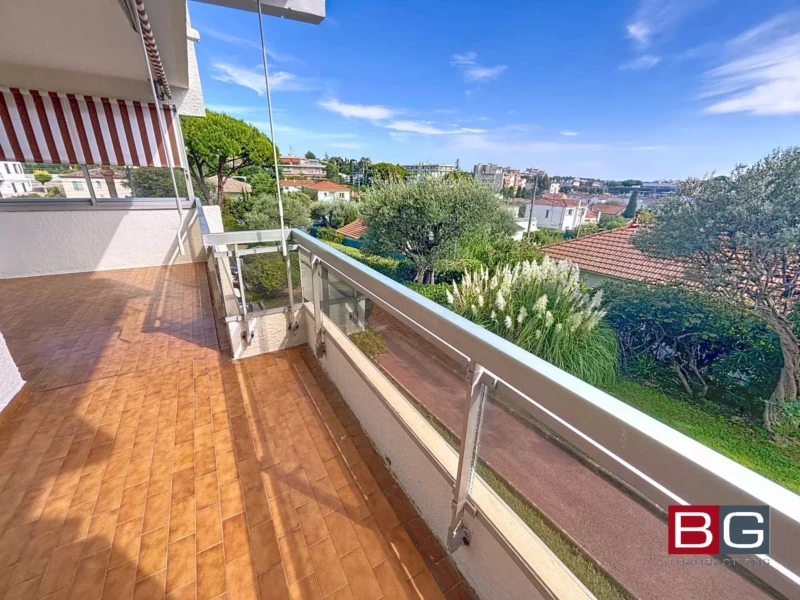 Une terrasse spacieuse avec vue sur un quartier résidentiel verdoyant et un ciel bleu dégagé.