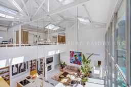 Ce salon lumineux et spacieux offre une vue magnifique grâce à ses grandes fenêtres en verre.