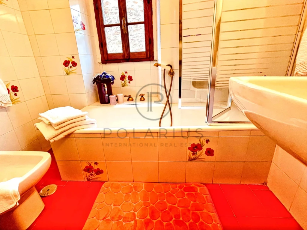 Salle de bain lumineuse avec baignoire et vue sur la fenêtre.